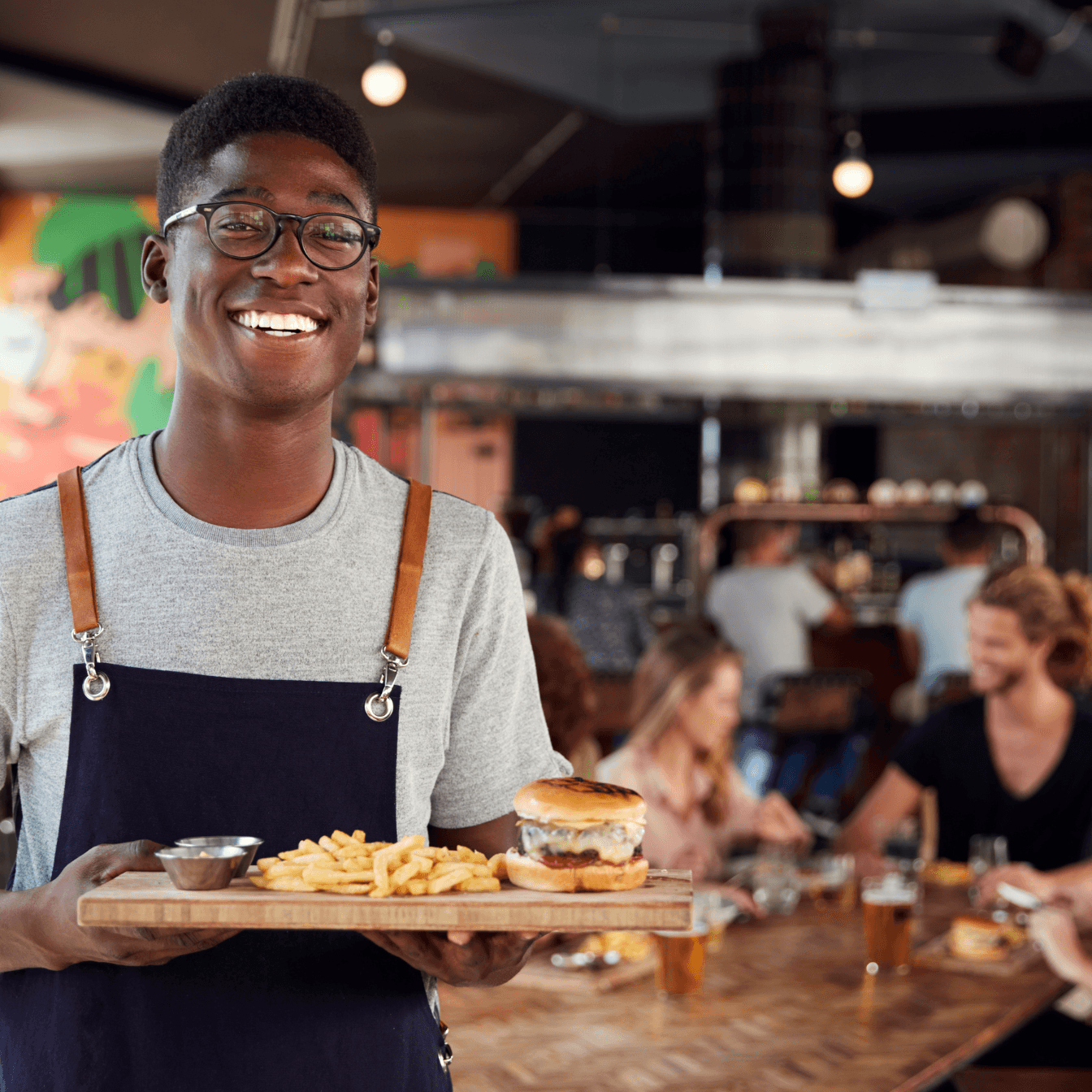 A restaurant owner smiling while serving a table